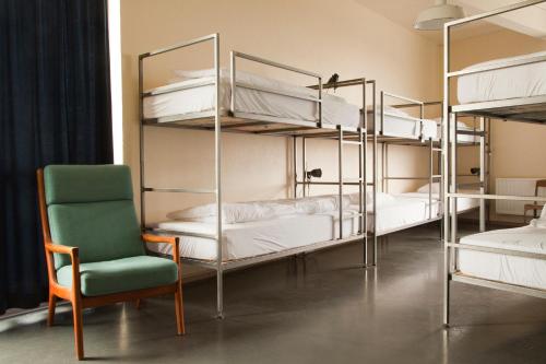 a room with four bunk beds with a chair and a chair at Kex Hostel in Reykjavík