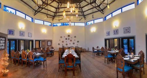 a large dining room with tables and blue chairs at Aranyak Resort in Tāla