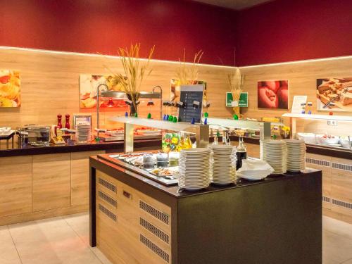 a restaurant kitchen with plates on a counter at Novotel Sofia in Sofia