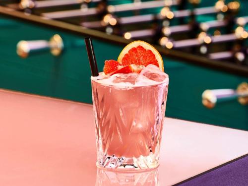 a drink with an orange slice on a table at Mama Shelter Prague in Prague