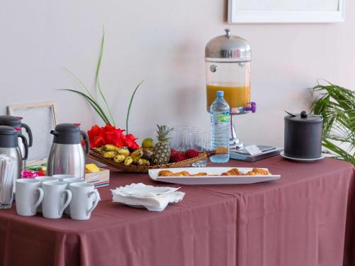 a table with a pink table cloth with food and a blender at Mercure Cayenne Royal Amazonia in Cayenne