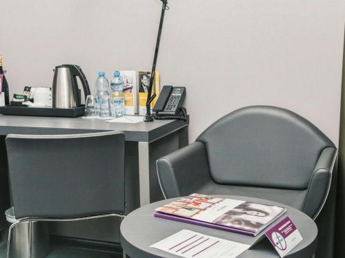 a desk with two chairs and a table with a book at Mercure Kyiv Congress in Kyiv