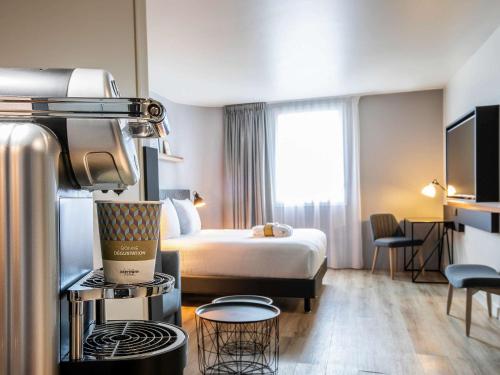 ジュヌヴィリエにあるHôtel Mercure Paris Gennevilliersのベッド付きのホテルルームとキッチン付きの客室を提供しています。