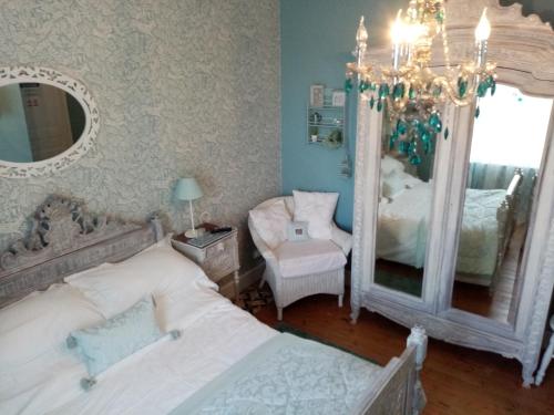 a bedroom with two beds and a mirror at Maison Jonela in Châteauneuf-du-Faou
