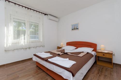 a bedroom with a bed and a window at Apartments Daria in Selce