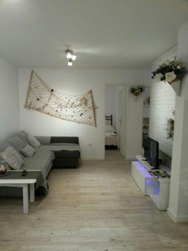 a living room with a couch and a tv at Appartamento Delia in Caleta De Fuste