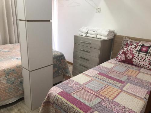 Un dormitorio con una cama y una cómoda y una cómoda con una cama. en Residenciais Gramado Encantos, en Gramado