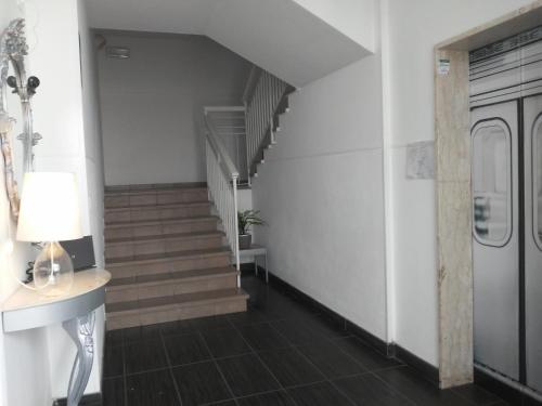 a hallway with stairs and a table and a lamp at Fasthotel in Cervia