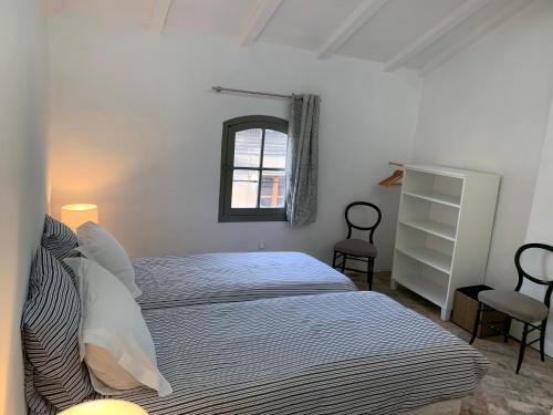 um quarto branco com uma cama e uma janela em COSY CENTRE HISTORIQUE em Arles