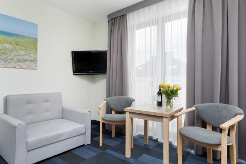 a hotel room with a table and two chairs and a window at Nawigator SPA in Rewal