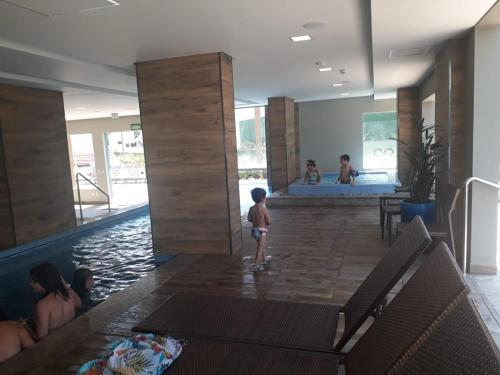 a young child standing in the water in a swimming pool at Apartamento de Luxo para até 6 pessoas em frente ao Thermas Olimpia in Olímpia