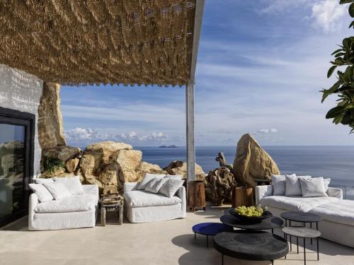 a patio with two couches and a view of the ocean at Myconian Panoptis Escape, a member of Small Luxury Hotels of the World in Elia Beach