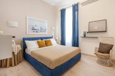 ローマにあるThe Prince Apartmentのベッドルーム(青いベッド1台、椅子付)