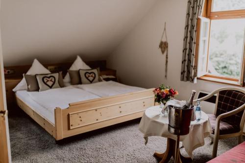 ein Schlafzimmer mit einem Bett, zwei Tischen und einem Fenster in der Unterkunft Hotel Zur alten Mühle in Neuenbürg