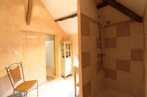 Habitación con baño con ducha y silla. en Les Orkys De Loire, en Chalonnes-sur-Loire