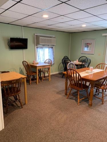 a conference room with tables and chairs and a television at Colonial Valley Motel in Farmington