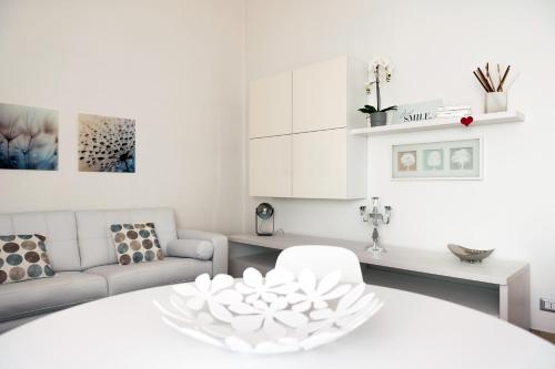 a white living room with a white table and a couch at Fly by Suites Pescara in Pescara