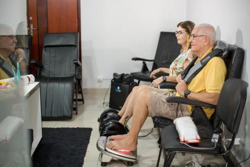 a man and woman sitting in chairs in a room at Hotel Morada do Sol in Caldas Novas