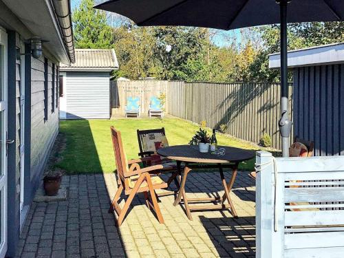 a patio with a table and chairs and an umbrella at 6 person holiday home in Hals in Hals