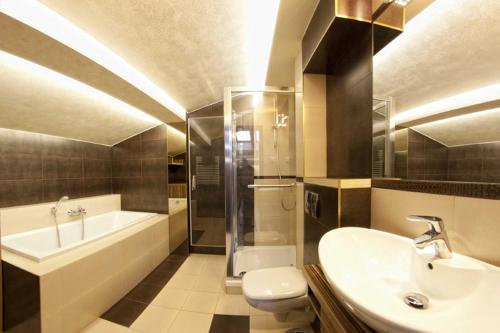 een badkamer met een wastafel, een bad en een toilet bij Yourplace Biskupia Old Town Apartments in Krakau