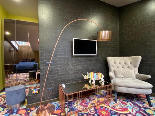a living room with a chair and a tv at ArtApart Vozdvigenka in Kyiv