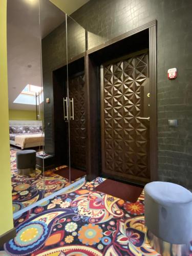 a bathroom with a door and a colorful carpet at ArtApart Vozdvigenka in Kyiv