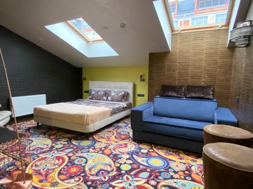 a bedroom with a bed and a couch and a skylight at ArtApart Vozdvigenka in Kyiv