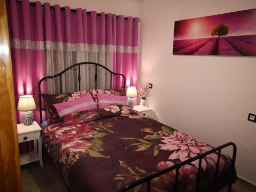 a bedroom with a bed and pink curtains at Eldorado Apartment La Mata in La Mata