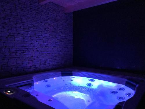 a jacuzzi tub in a room with a brick wall at Villa Aruba & Private SPA Suites in Keszthely
