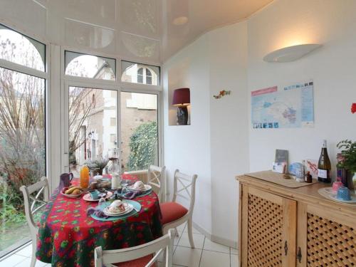 une salle à manger avec une table avec une nappe rouge dans l'établissement Les Orkys De Loire, à Chalonnes-sur-Loire