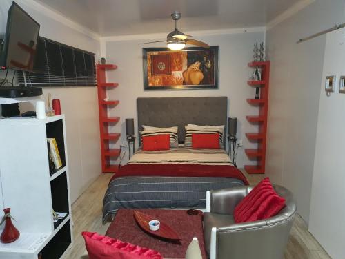 - une chambre avec un grand lit et des oreillers rouges dans l'établissement Atlantic Studio - Compact unit with Sea Views, à Melkbosstrand