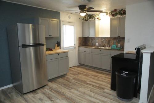 eine Küche mit weißen Schränken und einem Kühlschrank aus Edelstahl in der Unterkunft 1 bedroom with a fireplace close to base in Lawton