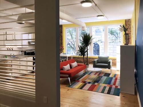 a living room with a red couch and two chairs at Downtown Vibration - Location - Comfort - Style in Atlanta