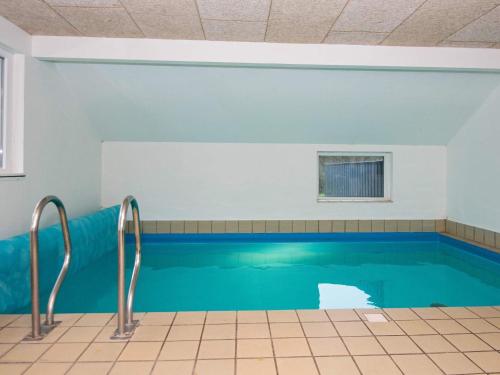 einen Pool mit blauem Wasser in einem Zimmer in der Unterkunft 8 person holiday home in Oksb l in Øster Vrøgum