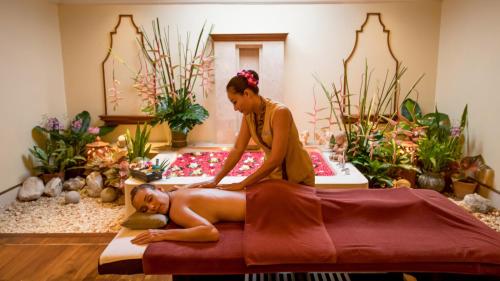 a woman sitting on a bed in a massage room at InterContinental Pattaya Resort by IHG in Pattaya South