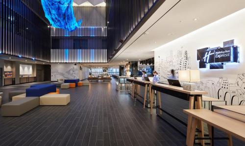 a lobby with a bar and people sitting at tables at Holiday Inn Express Seoul Hongdae, an IHG Hotel in Seoul