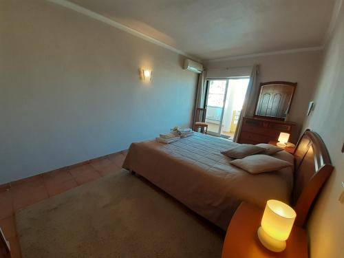 a bedroom with a large bed and a window at VP Flat with Balcony and Pool View in Alvor