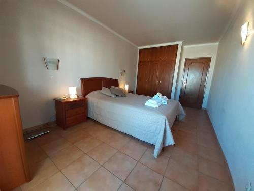 a bedroom with a white bed and two night stands at VP Flat with Balcony and Pool View in Alvor