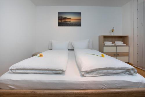 a bed with white sheets and yellow flowers on it at Tolles Einfamilienhaus nahe dem Bodensee in Lauterach