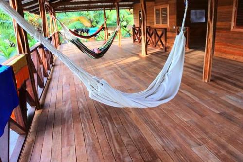 a hammock on a deck of a house at playa mecana kirita in Bahía Solano