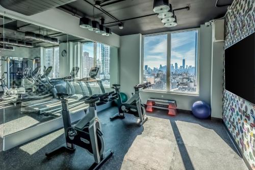 a gym with cardio machines and a large window at INNSiDE by Meliá New York Nomad in New York