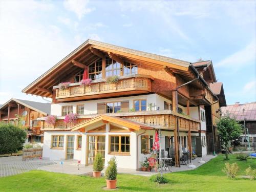 a large wooden house with a balcony at AlpStern Ferienwohnung in Oberstdorf
