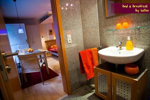 a bathroom with a sink and a room with a bedroom at bed & breakfast filderstadt by heller in Filderstadt
