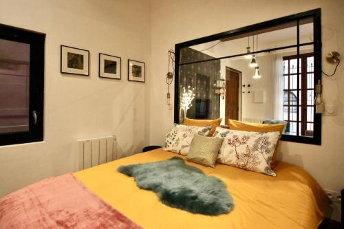 1 dormitorio con 1 cama con espejo grande en Pézenas Cocoon, en Pézenas