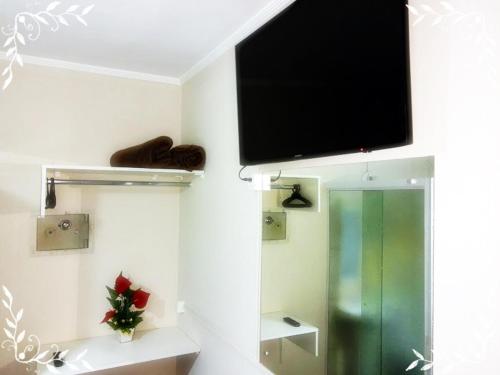 ソロカーバにあるHOTEL CASTELINHO DE SOROCABAの壁に薄型テレビが備わる客室です。