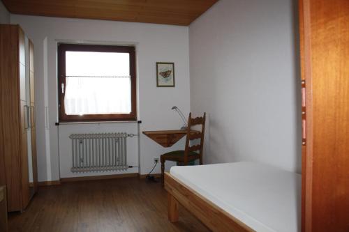 a room with a bed and a desk and a window at Ferienhaus Charlotte in Neunkirchen