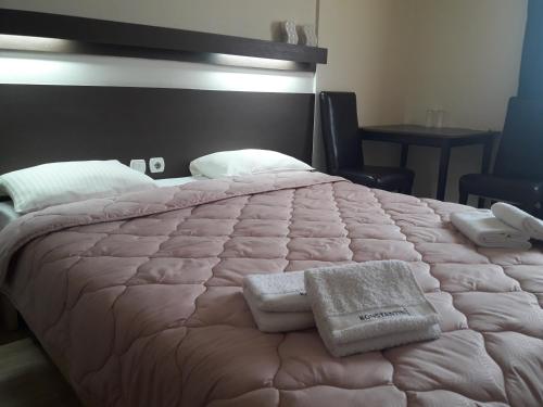 a bedroom with a large bed with two towels on it at Prenoćište Konstantin 2008 in Niš