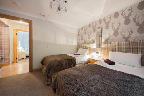 een hotelkamer met 2 bedden en een spiegel bij The Armoury in Glenfinnan