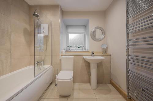 a bathroom with a toilet and a sink and a bath tub at The Armoury in Glenfinnan