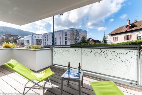 d'un balcon avec des chaises vertes et une table sur le toit. dans l'établissement Villa Aniciaca - Recent apartment with private and secure parking, à Annecy